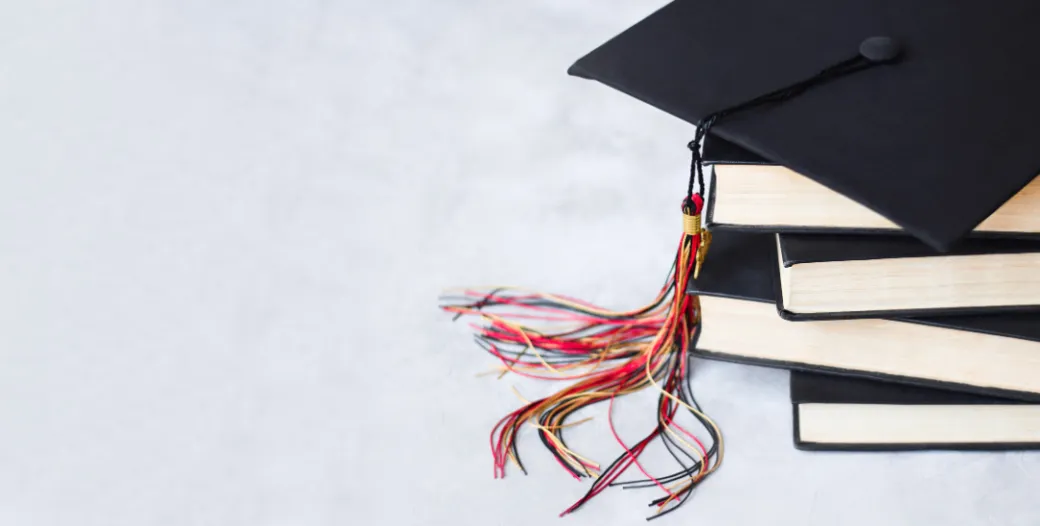 graduation cap atop books
