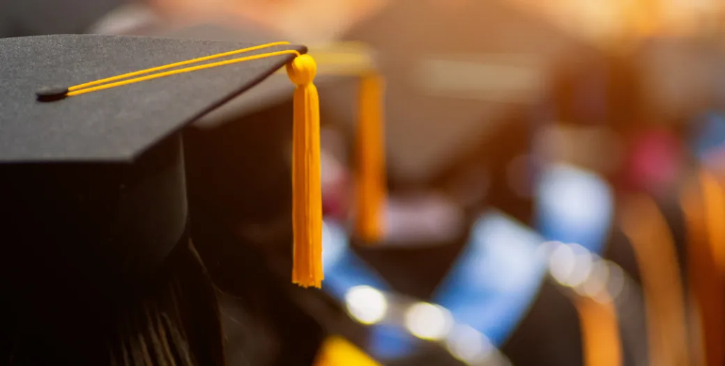 row of graduating students in cap and gown from the back