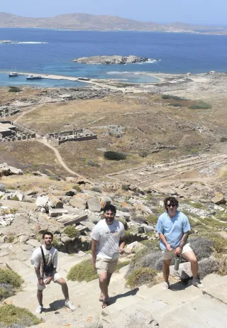 Xander and two other students standing on a hill overlooking the Aegean Sea