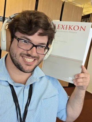 Pawlush holding a book title 