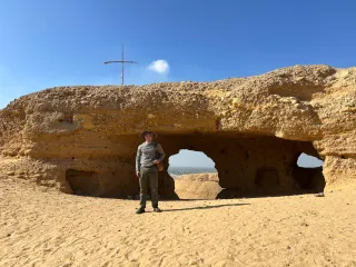 Me in front of one of the cliff-cut late antique monastic cells at Naqlum, with a view of the lush green Fayum through the large central opening.  
