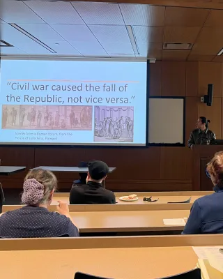 Edrman speaking to a slide titled 