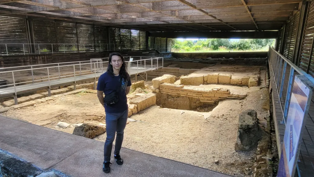 Erdman standing at an archeological site