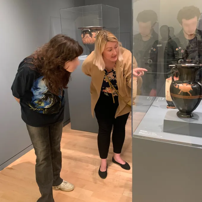 WahshU faculty member and Clayton high student observe an ancient Greek vase in the Kemper