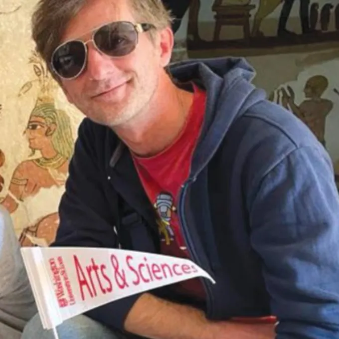 Aravecchia in Egypt holding a WashU Arts and Sciences flag