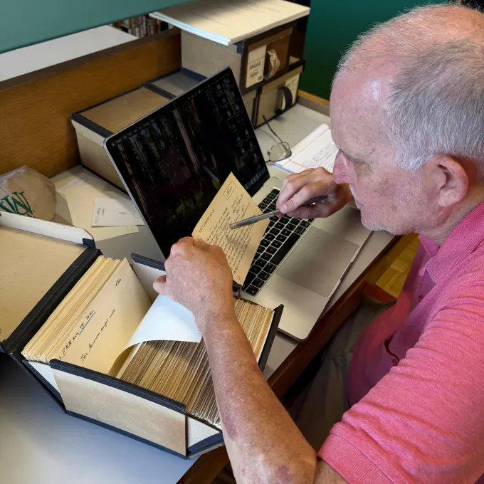 Moore studying an index card with his laptop open