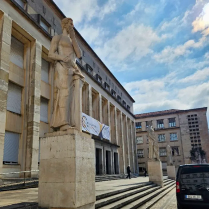 Classics inspired statuary in front of stone building