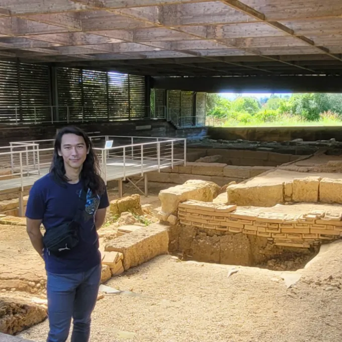 Erdman standing at an archeological site