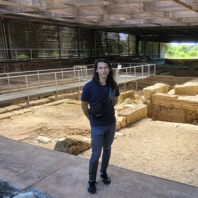 Erdman standing at an archeological site