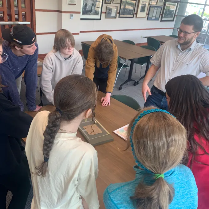 Will Seiving shows a group of freshman an example of papyri under glass