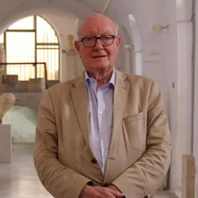 Colin Renfrew inside a building with vaulted ceilings