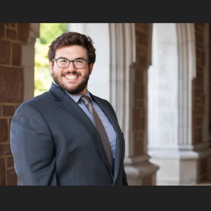 Jake Pawlush standing in front of WashU arches